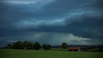 Dunkle Gewitterwolken hängen über der Landschaft in Penzberg in Oberbayern. In ganz Deutschland besteht die Gefahr von Unwettern.