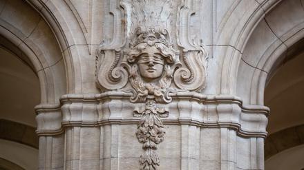 Ein Relief mit der Abbildung der Justitia, der römischen Göttin der Gerechtigkeit und des Rechtswesens, ist an einer Säule zu sehen.