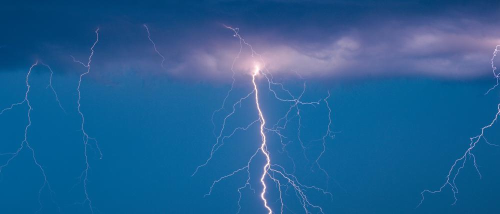 Blitze eines Gewitters leuchten am Abendhimmel. (Symbolbild)