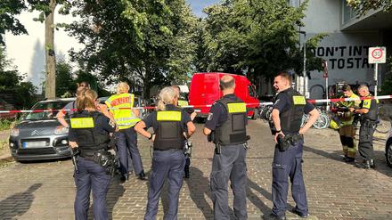 Einsatzkräfte der Polizei stehen an einem Tatort.