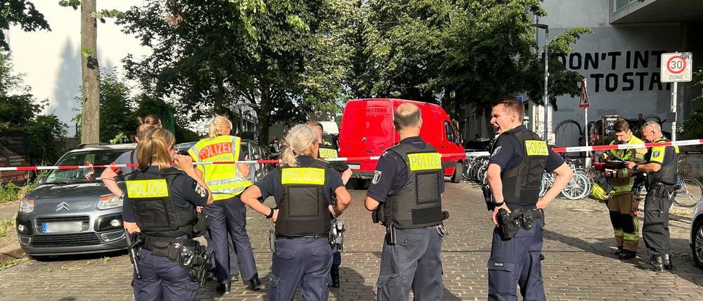 Einsatzkräfte der Polizei stehen an einem Tatort.