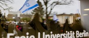 Eine Israel-Flagge spiegelt sich bei einem stillen Protest einer Initiative für die Sicherheit jüdischer Studierender in einer Scheibe der Freien Universität Berlin. 