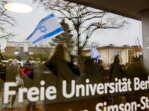Eine Israel-Flagge spiegelt sich bei einem stillen Protest einer Initiative für die Sicherheit jüdischer Studierender in einer Scheibe der Freien Universität Berlin. 