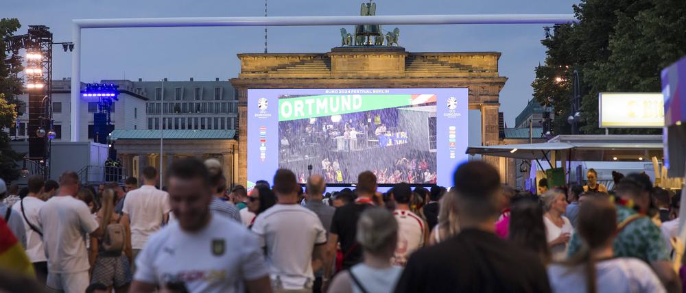 Fanzone, Spielunterbrechung aufgrund von Gewitter in Dortmund, Berlin, 29.06.2024 Fassballfans feiern und informieren sich auf der Fanzone am Brandenburger Tor nach der Spielunterbrechung des Achtelfinalspiels Deutschland-Dänemark aufgrund eines Gewitters über dem Stadion in Dortmund, Berlin, 29.06.2024 Berlin Fanzone *** Fanzone, match interruption due to thunderstorm in Dortmund, Berlin, 29 06 2024 Fassball fans celebrate and inform themselves at the Fanzone at the Brandenburg Gate after the interruption of the round of 16 match between Germany and Denmark due to a thunderstorm over the stadium in Dortmund, Berlin, 29 06 2024 Berlin Fanzone Copyright: xBenxKriemannx