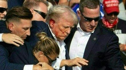 Agenten des Secret Services führen Donald Trump nach dem Anschlag von der Bühne einer Wahlkampfveranstaltung in Butler, Pennsylvania.