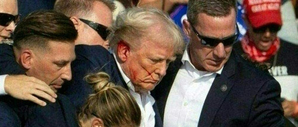 Agenten des Secret Services führen Donald Trump nach dem Anschlag von der Bühne einer Wahlkampfveranstaltung in Butler, Pennsylvania.