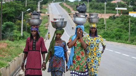 Frauen tragen Milch zum Verkauf in der Elfenbeinküste.