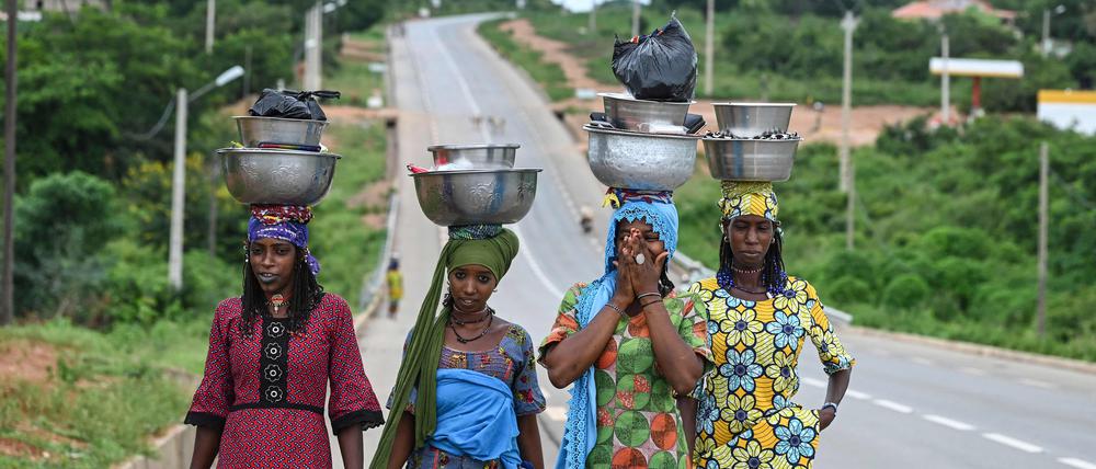Frauen tragen Milch zum Verkauf in der Elfenbeinküste.
