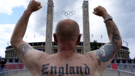 Ein englischer Fan hebt vor dem Olympiastadion die Hände zum Himmel.