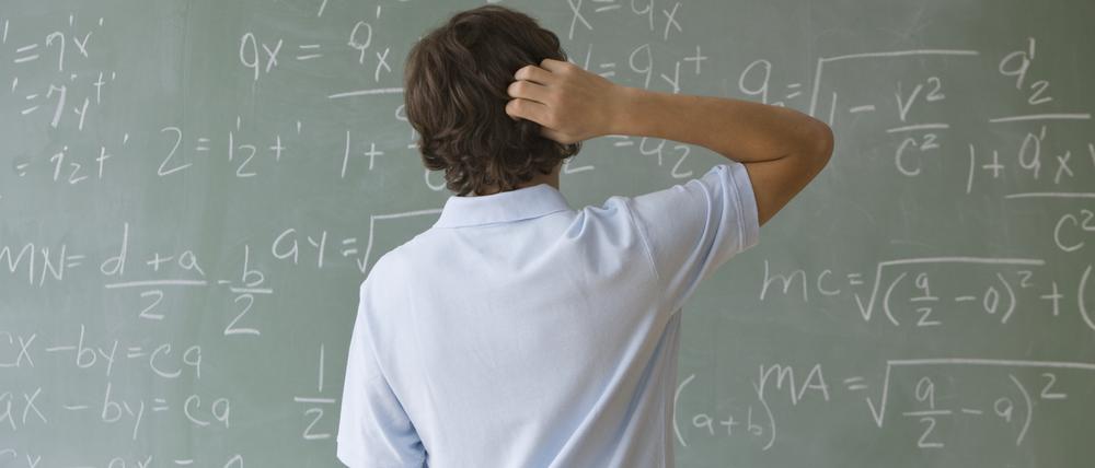 Ein Junge steht ratlos vor einer Schultafel. Laut einer Studie des Bankenverbands kennen nur 44 Prozent der befragten 700 Jugendlichen den Begriff Inflation.