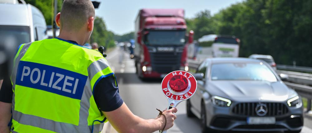 ARCHIV - 21.06.2024, Brandenburg, Frankfurt (Oder): Ein Beamter der Bundespolizei steht auf der Autobahn A12 nahe dem deutsch-polnischen Grenzübergang und stoppt ein Auto mit polnischen Fußballfans, die unterwegs nach Berlin zum EM-Spiel Polen gegen Österreich sind. (zu dpa: «Verschärfte EM-Grenzkontrollen enden - Kritik im Südwesten») Foto: Patrick Pleul/dpa +++ dpa-Bildfunk +++