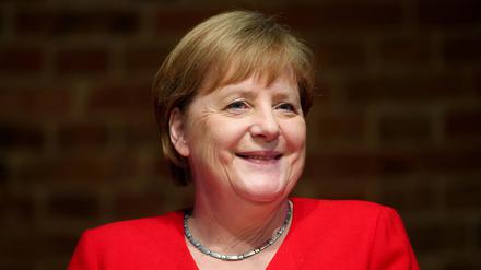 Angela Merkel (CDU), ehemalige Bundeskanzlerin, sitzt während eines Festaktes zum 50-jährigen Jubiläum des deutschen Entwicklungshelfergesetzes während einer Diskussion auf einem Podium. 