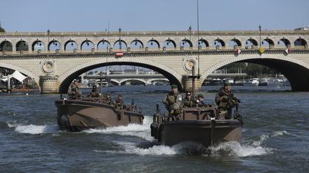 Soldaten patrouillieren mit Booten auf der Seine, um die Eröffnungsfeier der Olympischen Spiele in Paris für Sportler und Zuschauer sicherzumachen. 