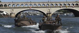 Soldaten patrouillieren mit Booten auf der Seine, um die Eröffnungsfeier der Olympischen Spiele in Paris für Sportler und Zuschauer sicherzumachen.
