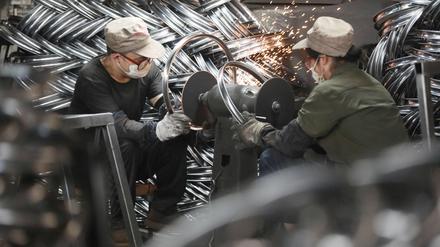 Chinesische Arbeiter in einer Fahrrad-Fabrik in Hangzhou. 