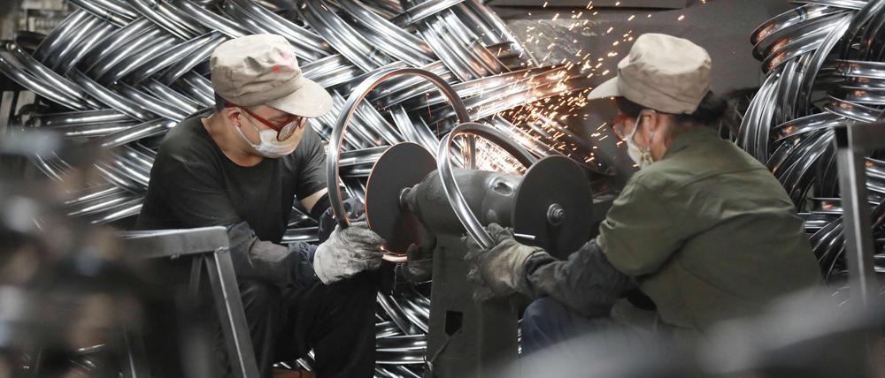 Chinesische Arbeiter in einer Fahrrad-Fabrik in Hangzhou. 