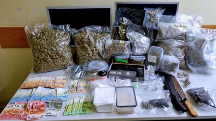 Die Beamten präsentieren den Drogen- und Waffenfund.