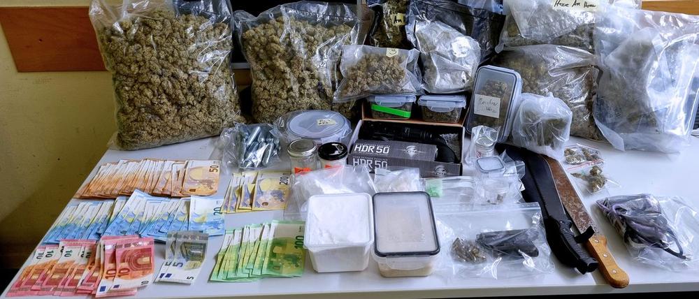 Die Beamten präsentieren den Drogen- und Waffenfund.