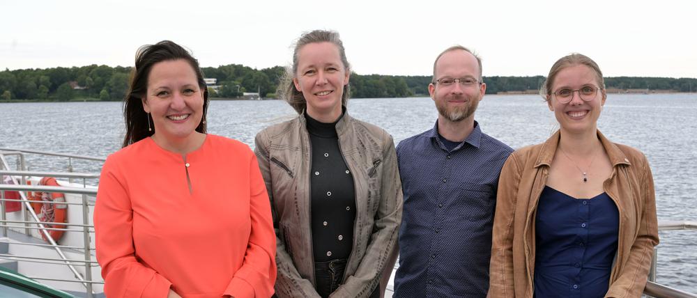 Brandenburgs Wissenschaftsministerin Manja Schüle (SPD), Preisträgerin Ulrike Lucke, Professorin für komplexe multimediale Architektur, und ihr Team, bestehend aus Tobias Moebert und Lilian Hasse (v.l.), stehen auf dem Deck des Ausflugsschiffes MS Sanssouci.