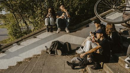 Eine Gruppe von jungen Menschen sitzt auf einer Treppe.