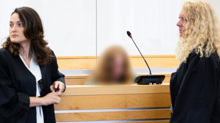Die Angeklagte sitzt vor Verhandlungsbeginn in einem Gerichtssaal im Landgericht Hannover. 