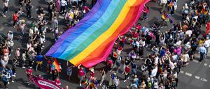 Menschen ziehen auf der 45. Berlin Pride-Parade zum Christopher Street Day (CSD) mit einer Regenbogenfahne durch die Stadt.