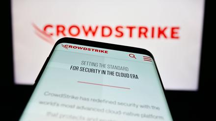 Mobile phone with website of cybersecurity company CrowdStrike Holdings Inc. on screen. Stuttgart, Germany - 03-31-2023: Mobile phone with website of cybersecurity company CrowdStrike Holdings Inc. on screen in front of logo. Focus on top-left of phone display. Copyright: xZoonar.com/TimonxSchneiderx 20112382