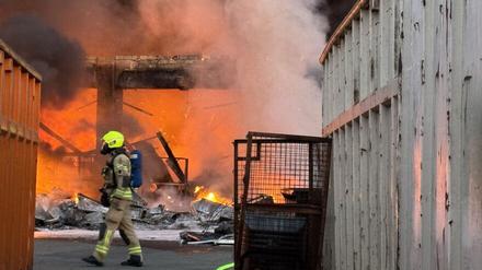 Einsatzkräfte der Berliner Feuerwehr löschen auf einem Recyclinghof in Berlin-Alt-Hohenschönhausen brennenden Elektroschrott.
