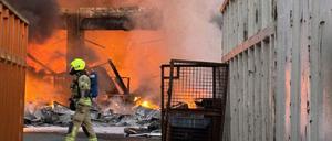 Einsatzkräfte der Berliner Feuerwehr löschen auf einem Recyclinghof in Berlin-Alt-Hohenschönhausen brennenden Elektroschrott.