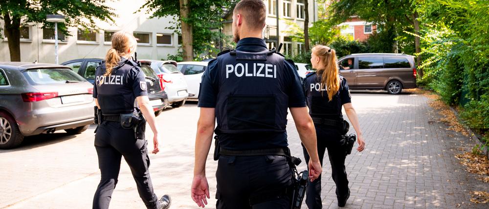 Polizisten gehen über den Parkplatz einer Schule. Auf dem Gelände einer Volkshochschule in Wedel bei Hamburg ist eine Lehrkraft niedergestochen worden.