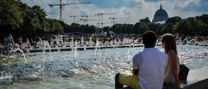 Berliner suchen Abkühlung an den Springbrunnenbecken auf dem Alexanderplatz in Berlin.