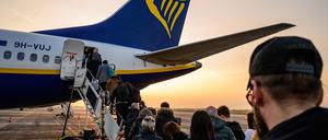 (FILES) Passengers wait to board an aircraft of low cost Irish airline Ryanair at the Berlin-Brandenburg airport in Schoenefeld near Berlin, Germany, on March 13, 2024. Irish no-frills airline Ryanair on July 22, 2024 said net profit almost halved in its first quarter as lower air fares offset a jump in demand. Profit after tax dropped 46 percent to 360 million euros ($392 million) in the three months to the end of June compared with 12 months earlier, Ryanair said in a results statement. (Photo by John MACDOUGALL / AFP)