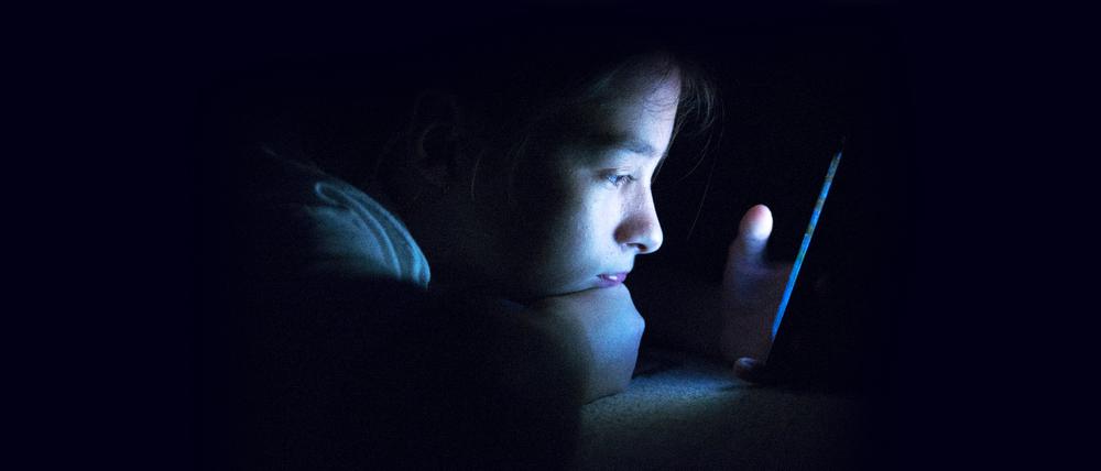 Eltern wissen oft nicht, was ihre Kinder im Netz machen. Ein Junge sitzt allein vor seinem Smartphone.