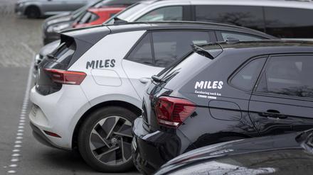 Zwei Fahrzeuge des Carsharing-Anbieters Miles parken am Straßenrand.