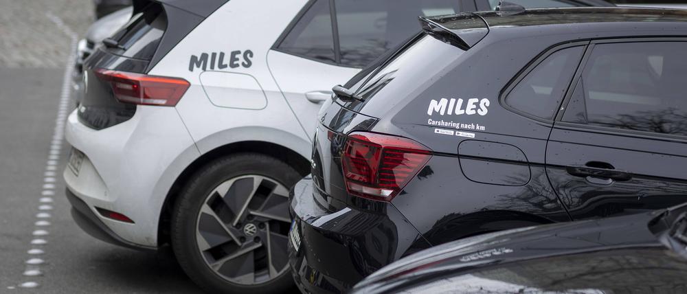 Zwei Fahrzeuge des Carsharing-Anbieters Miles parken am Straßenrand.