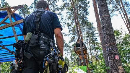 Einsatzkräfte der Polizei suchen im Waldcamp nahe der Tesla-Gigafactory Berlin-Brandenburg nach Personen, die das bereits abgesperrte Gelände eventuell noch nicht verlassen haben.