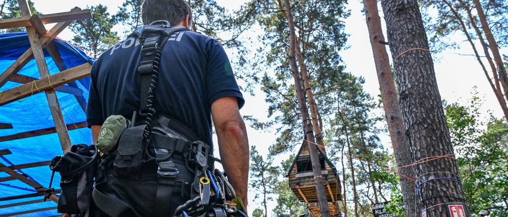 Einsatzkräfte der Polizei suchen im Waldcamp nahe der Tesla-Gigafactory Berlin-Brandenburg nach Personen, die das bereits abgesperrte Gelände eventuell noch nicht verlassen haben.