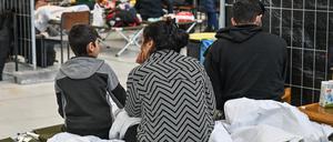 Migranten sitzen in der neu eingerichteten zentralen Bearbeitungsstelle der Bundespolizei und des Bundesamtes für Migration und Flüchtlinge (BAMF). 