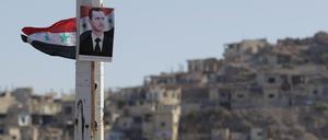 Ein Portrait von Baschar al-Assad, Präsident von Syrien, hängt an einem Pfeiler. 
