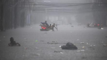 Retter paddeln am 24. Juli 2024 in einer überfluteten Straße in Manila inmitten starker Regenfälle.