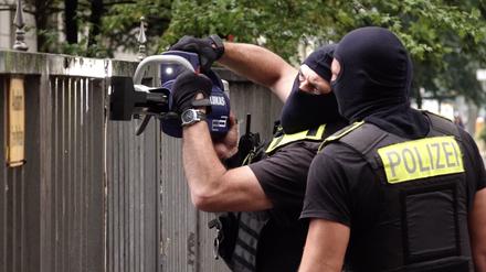 Vermummte Polizisten öffnen ein Tor vor einem Gebäude, in dem sich das Islamische Zentrum Berlin in der Ordensmeisterstraße befindet.