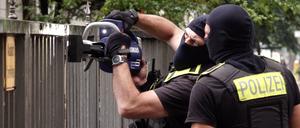 Vermummte Polizisten öffnen ein Tor vor einem Gebäude, in dem sich das Islamische Zentrum Berlin in der Ordensmeisterstraße befindet.
