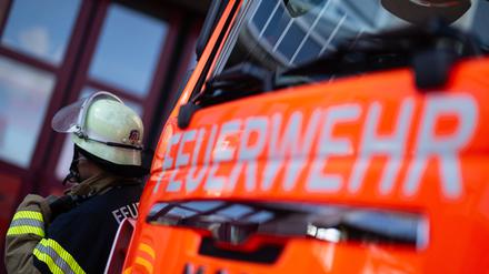 Eine Einsatzkraft der Feuerwehr steht neben einem Einsatzfahrzeug. (Symbolbild)