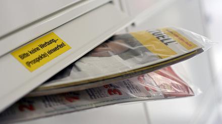 Gratis-Werbeprospekte auf Papier gedruckt stecken in einem Briefkasten.
