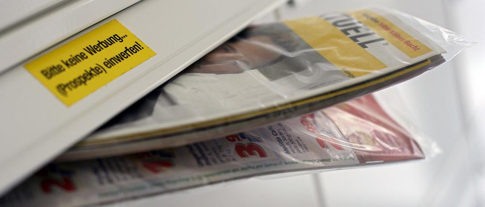 Gratis-Werbeprospekte auf Papier gedruckt stecken in einem Briefkasten.