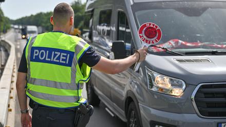 Ein Bundespolizist steht auf der Autobahn A12 nahe dem deutsch-polnischen Grenzübergang und stoppt ein Auto bei der Einreise nach Deutschland.