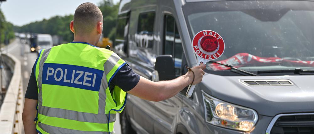 Ein Bundespolizist steht auf der Autobahn A12 nahe dem deutsch-polnischen Grenzübergang und stoppt ein Auto bei der Einreise nach Deutschland.