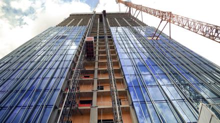 Die noch unfertige Fassade des Estrel-Towers mit Baukran, der mit dem Rohbau verankert ist. 