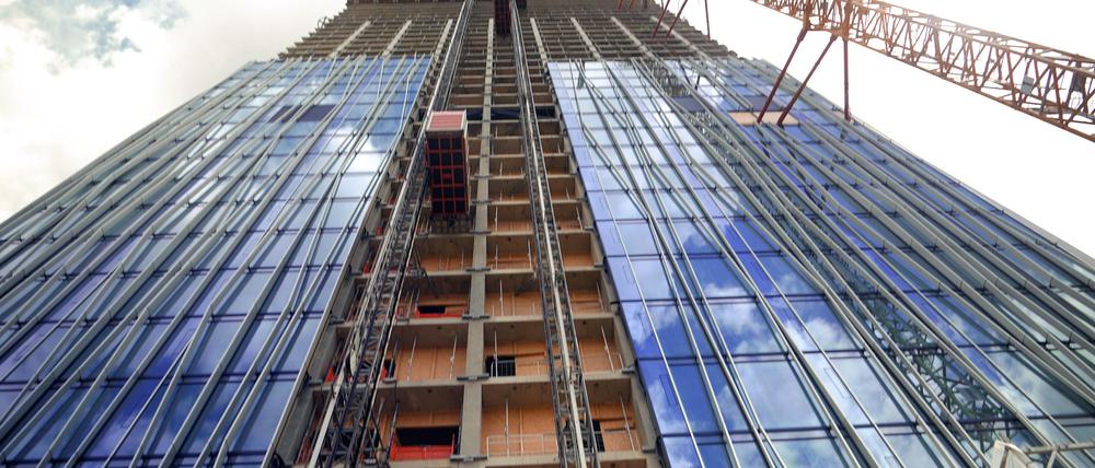 Die noch unfertige Fassade des Estrel-Towers mit Baukran, der mit dem Rohbau verankert ist. 