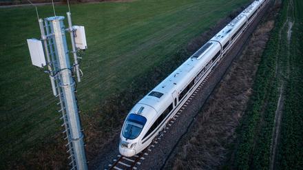 Ein Testzug der Deutschen Bahn fährt an einem Antennenmast vorbei (Luftaufnahme mit einer Drohne). 
